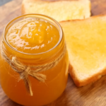 A jar of homemade pineapple jam with a spoon, ready to be used in various recipes.