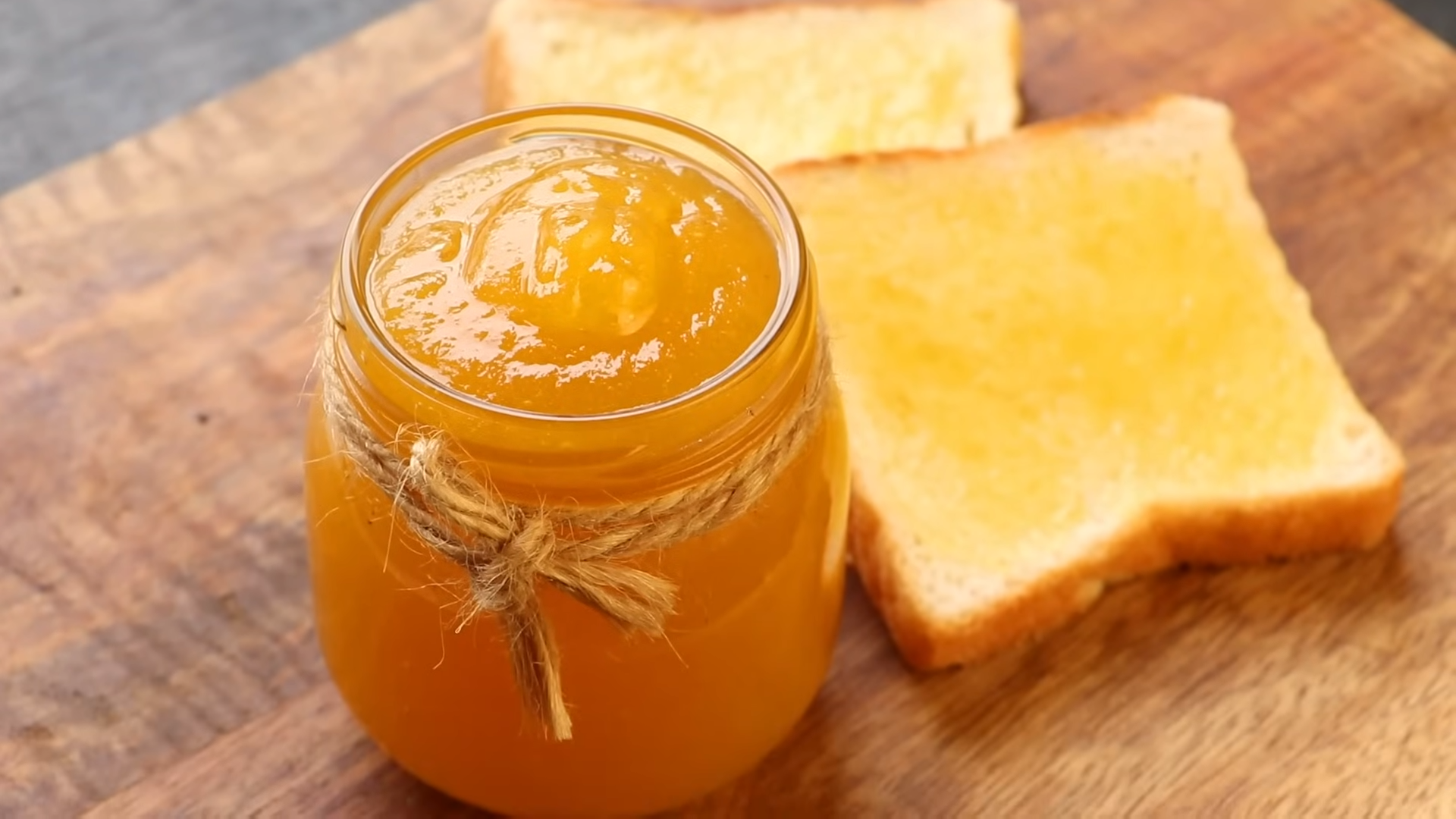 A jar of homemade pineapple jam with a spoon, ready to be used in various recipes.